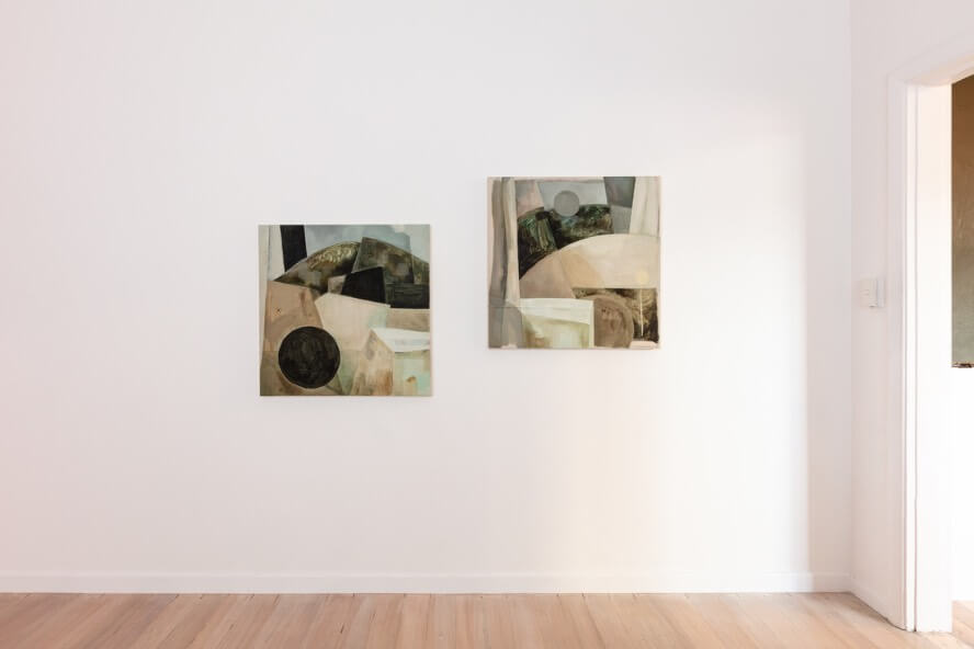Two square paintings hanging, offset, on a gallery wall.